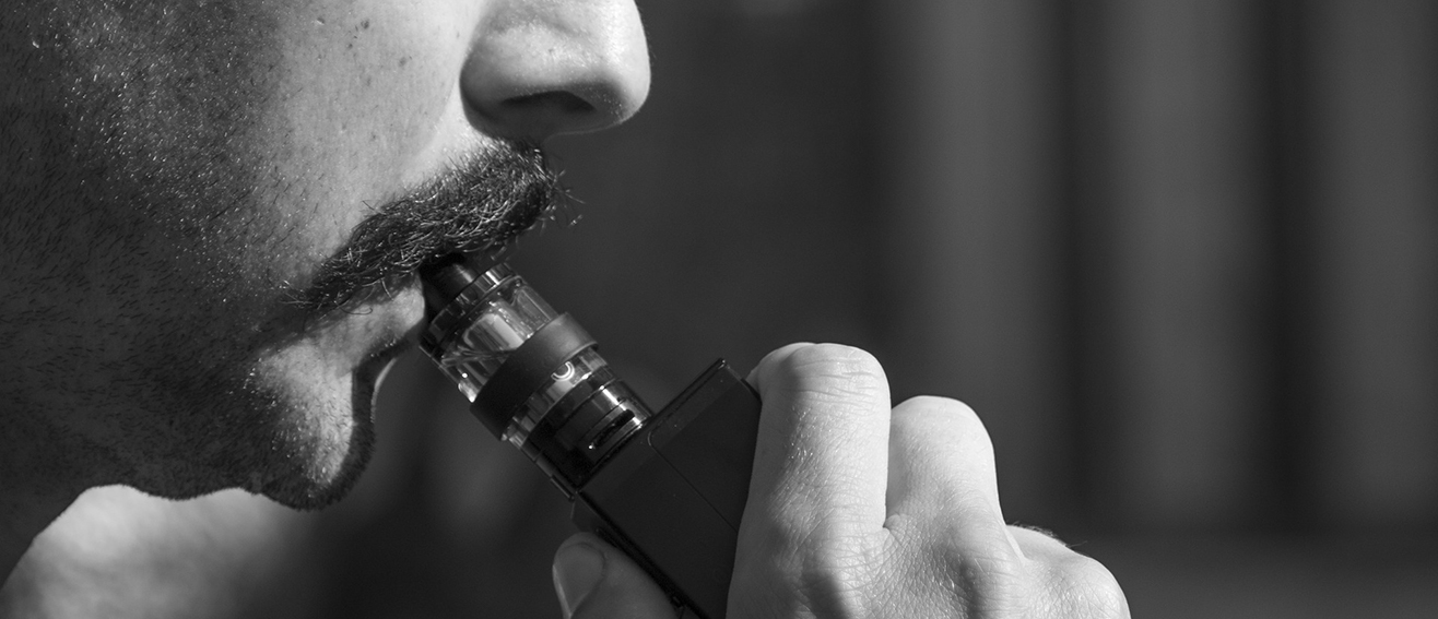 man using vape with facial hair