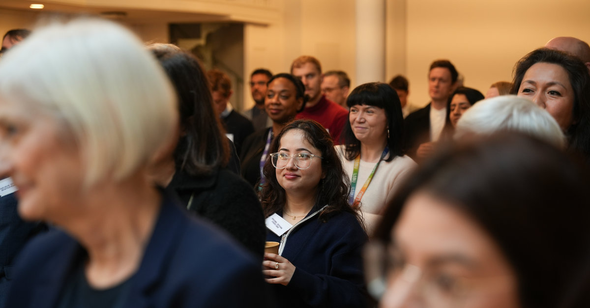 People stand looking at a speaker who is off-camera