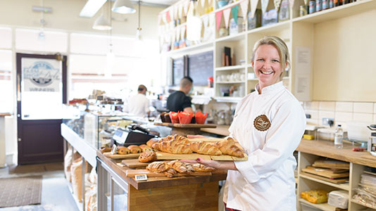 Dee holding a tray of croissants