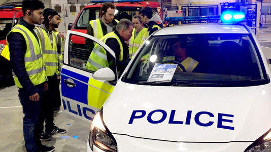 Students look at a police car