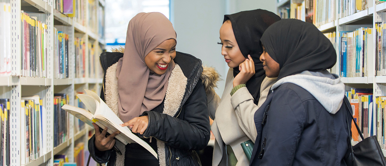 3 females laugh in library