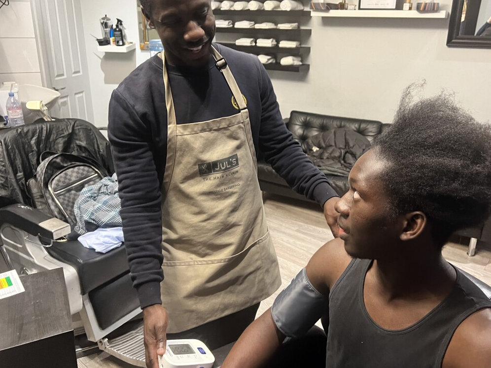 A barber takes a man's blood pressure
