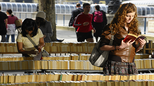 Students reading books at a market on Southbank