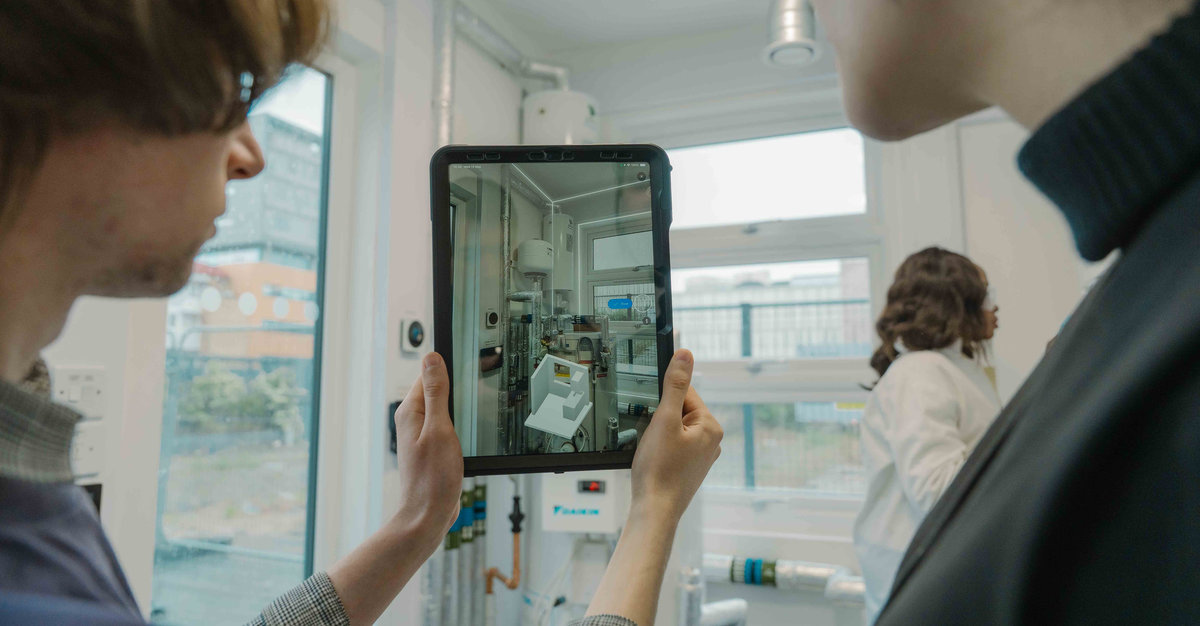 Two people look at an iPad