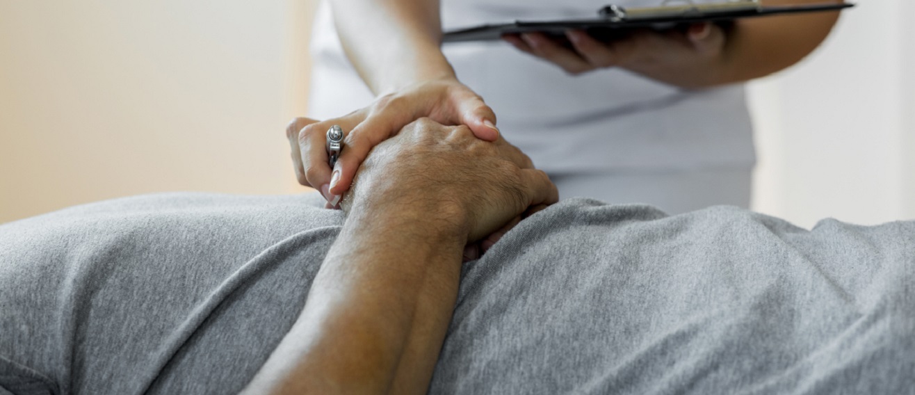 Nurse holds patient's hand